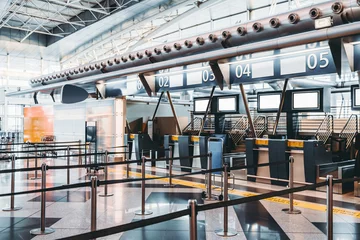 Fototapete Flughafen Moderne Check-in-Zone des Flughafens: Gepäckannahmeterminals mit Gepäckförderbandfördersystemen, zahlreiche Leerinformations-LCD-Bildschirmmodelle, indizierte Check-in-Schalter mit Ziffern oben