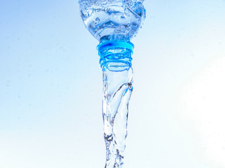 Bottle dropping with water splashing isolated on white background.