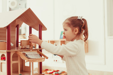 Girl playing with a dollhouse