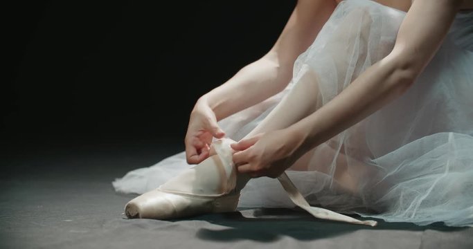 ballerina putting on pointes before the performance, dolly shot