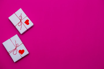 Happy Valentine day composition: white gift boxes with red heart on pink background, photo template. Top View. View from above.
