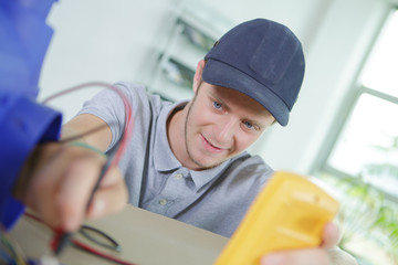 young electrician fixing a cable