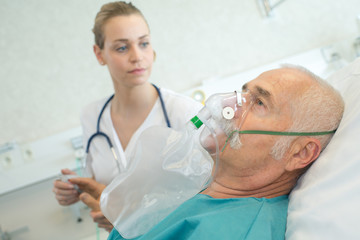 close-up of senior man using oxygen mask in clinic