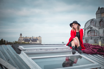 Girl in red posing on the roof of old city
