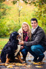 Naklejka na ściany i meble Happy couple with dog enjoying autumn in nature