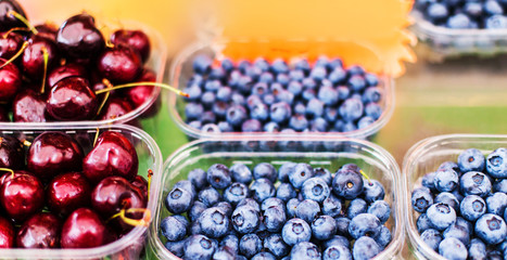 Various berries from a local farmer market.  Healthy local food market concept. Variety of berries in a box -  blackberry, raspberry, strawberry, cherry.