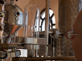 Man inspecting meter of alembic inside distillery