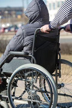 People with limited mobility take a walk with rollator wheelchair outdoors