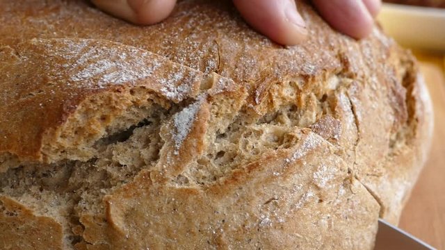 Fresh bread is cut with a knife. Discount of bread.