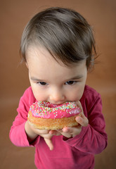 Little girl eating donuts