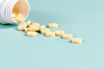 Pills spilled from a package on the blue table