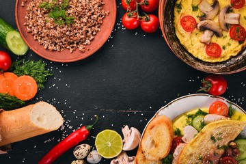 Breakfast. Omelet, buckwheat, mushrooms, nuts, fresh vegetables. On a wooden background. Top view. Copy space.