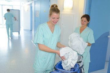 Auxiliary nurses collecting laundry
