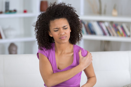 Woman rubbing aching shoulder