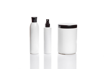 Set of cosmetic products in white containers on light background.