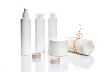 Set of cosmetic products in white containers on light background.