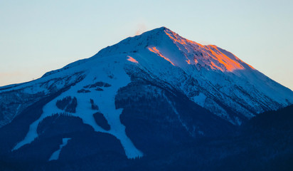 Beautiful sunset view on the high winter mountains peaks, on the sky background. Mountain ice paradise landscape, sunrise light.