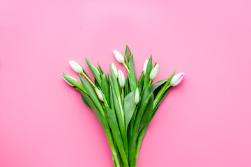 Pale pink spring tulips on pastel pink background top view copy space