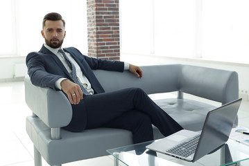 businessman sitting in the lobby of a modern office.