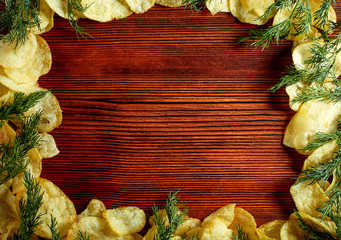 Fried potatoes with salt, dill, spices on a wooden Board on brown background with copy space. The view from the top