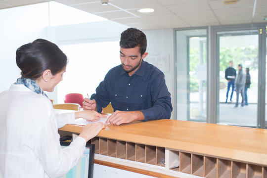 man checking in at reception desk