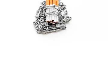 Quit smoking. Cigarettes in chains on white background copy space
