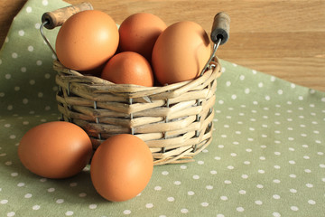 Fresh chicken egg in a basket on the kitchen table. Easter decor in a rural style.