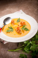 soup with carrot pumpkin and shrimp, selective focus