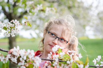 child and blossoming flowers in garden