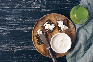 Breakfast cheese, crackers, juice on a dark rustic background.Videos from above, copy space.