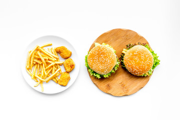 Fast food restaurant. Chiken nuggets, burgers and french fries on white background top view