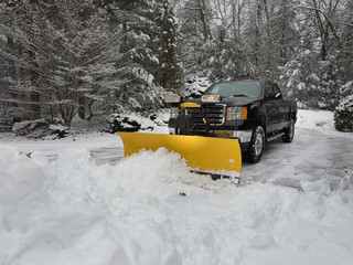 snow plow clearing a parking lot after  storm