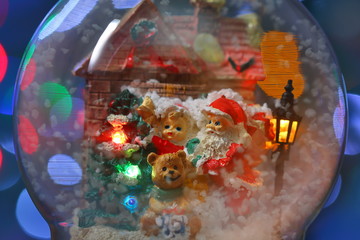 Santa Claus with a child and Teddy Bear near the house with street illumination close-up. Long exposure time
