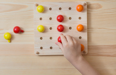 The child is playing with wooden colorful balls. Game for children