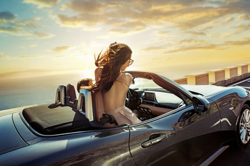 Relaxed couple riding a convertible - obrazy, fototapety, plakaty