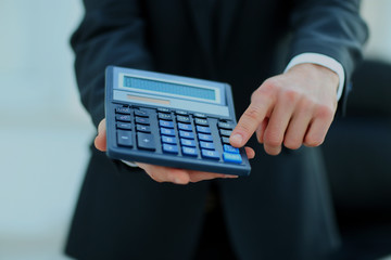 Businessman holding calculator.