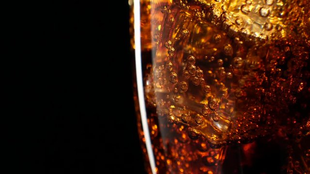 Cola with ice background. Large glass of cold coke with ice cubes close-up. 4k