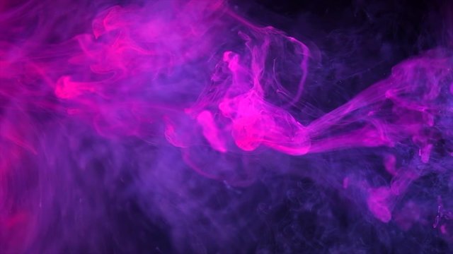 Abstract purple neon flowing ink in water over black background. Dropping colorful ink into the water. Slow motion 4K UHD video footage. 3840X2160
