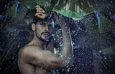 Fotobehang Knappe man die naar de tropische regen staart © konradbak