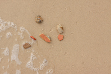 Pebbles on the sand near sea. Sea stones on sand. Summer beach background. View from above