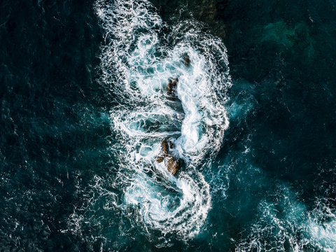 Abstract aerial of waves hitting a stack of rocks on Madeira, Portugal