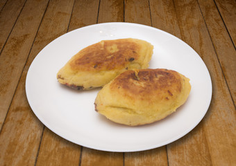 Two potato pies with mushroom filling on wood surface
