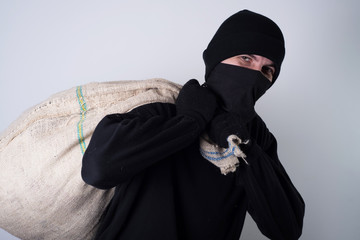 masked thief with bag on back 