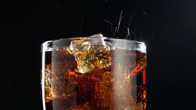Cola with ice background. Large glass of cold coke with ice cubes close-up.