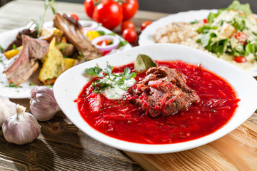 Red beet vegetable soup borscht on wooden background. Ukrainian and russian national food. Close-up.