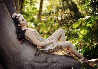 Relaxed lady laying on the giant tropical tree