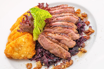 delicious grilled duck breast with cabbage and potato dumpling on white plate