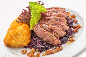 delicious grilled duck breast with cabbage and potato dumpling on white plate