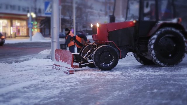 Cleaning car plowing snow to the side of the street. Cleaning the side of the road after a snowfall.