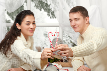 young couple shows a heart of candy, happy people - romantic and love concept
